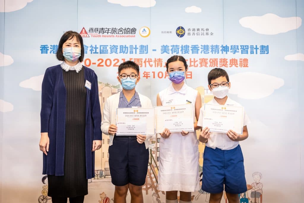 教育局常任秘書長李美嫦太平紳士頒獎予小學組三位得獎者:(左起)冠軍何卓衡、亞軍廖萱嵐,以及季軍陳天儒。
